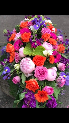 Orange pink and purple casket spray